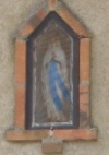 The niche in the South Barn's north wall, holding the statue of the Lady of Pontmain
