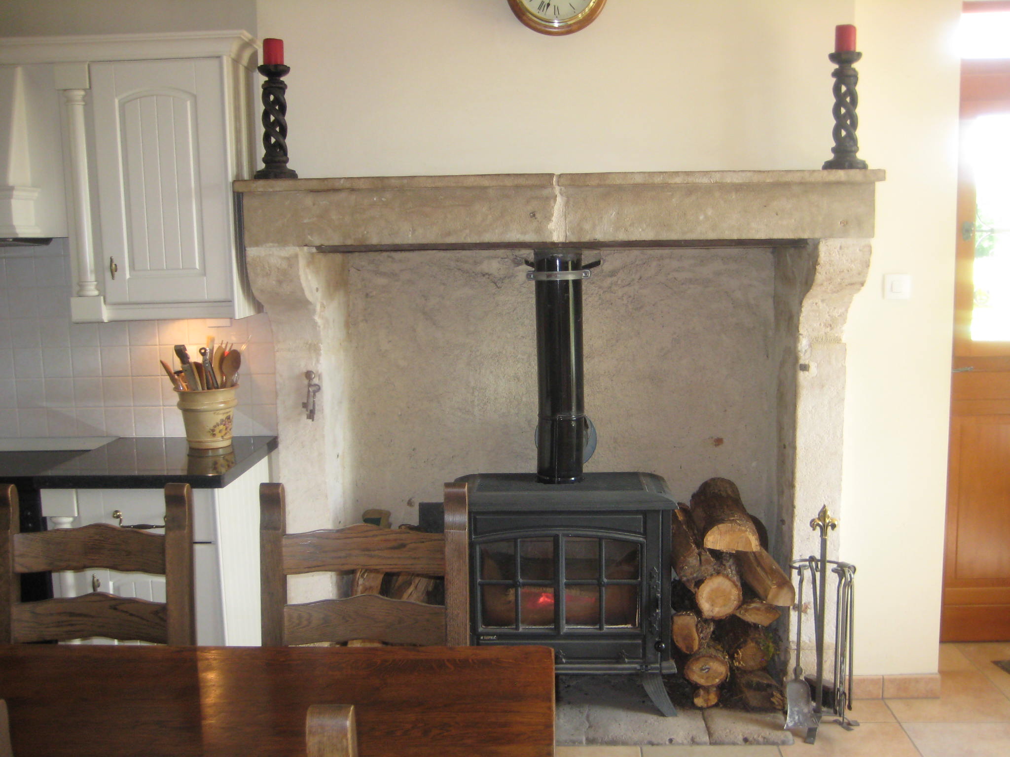 The fireplace in the kitchen, laid with a wood-burning stove